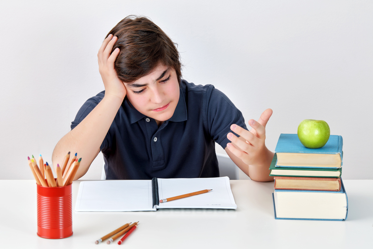 Secondary school boy student with ADHD is feeling confused and angry while doing his homework