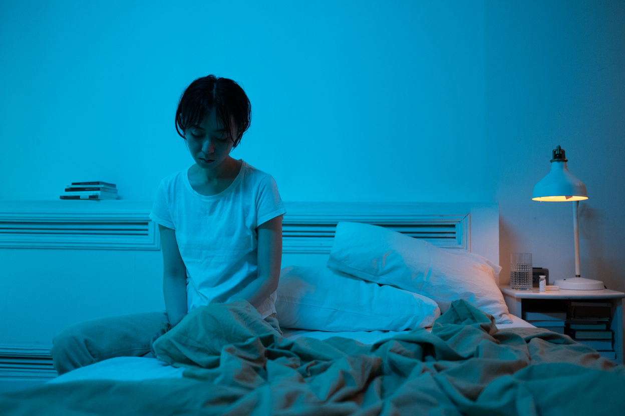 A Lonely Woman Sitting on a Bed