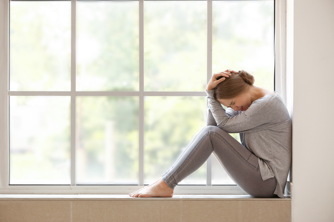 Woman Having Panic Attack near Window