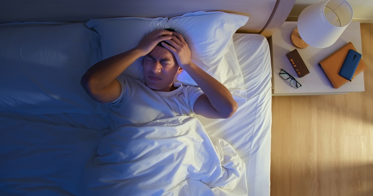 Man with Headache Lying on the Bed 